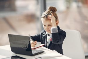 Child dressed professionally with a laptop