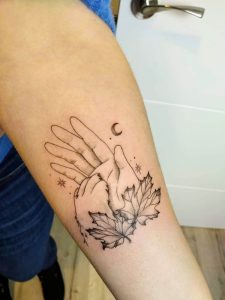 My first tattoo symbolizes the ever-present love of dogs: it's a dogs paw in my hand with my first family dog Maple symbolized by the leaves, and a crescent moon symbolizing our second dog Luna.